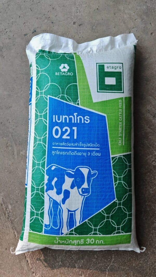 ภาพนี้แสดงถึง ถุงอาหารสัตว์สำเร็จรูปชนิดเม็ด ภายใต้แบรนด์ เบทาโกร (Betagro) รุ่น 021 Calf Starter Cattle Feed ซึ่งเป็นอาหารสำหรับ ลูกโคแรกเกิดถึงอายุ 3 เดือน โดยมีรายละเอียดที่ระบุบนถุงดังนี้: ชื่อแบรนด์: Betagro ชื่อสินค้า: เบทาโกร 021 ประเภทสินค้า: อาหารสัตว์ผสมสำเร็จรูปชนิดเม็ด กลุ่มเป้าหมาย: ลูกโคแรกเกิดถึงอายุ 3 เดือน น้ำหนักสุทธิ: 30 กิโลกรัม ภาพประกอบบนถุงแสดงรูป ลูกโค พร้อมพื้นหลังลวดลายสีเขียวและสีน้ำเงิน ซึ่งช่วยเน้นความชัดเจนของผลิตภัณฑ์ เหมาะสำหรับการใช้งานในฟาร์มปศุสัตว์ที่เลี้ยงโคตั้งแต่แรกเกิด